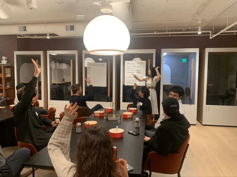 Longitude participants raising their hands during a group session